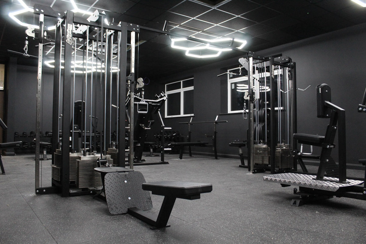 Kraftbereich eines Fitnessstudios mit Gymleco-Kabelzugstationen, Bank und freier Trainingsfläche