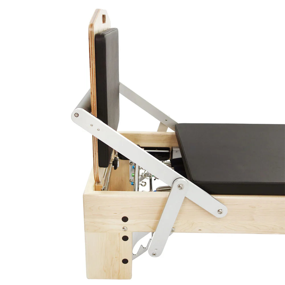 Align-Pilates Jump Board M-Serie – Ahornholz-Sprungplattform mit schwarzem Polster am Ahorn-Reformer montiert, Seitenansicht mit Halterungsmechanik