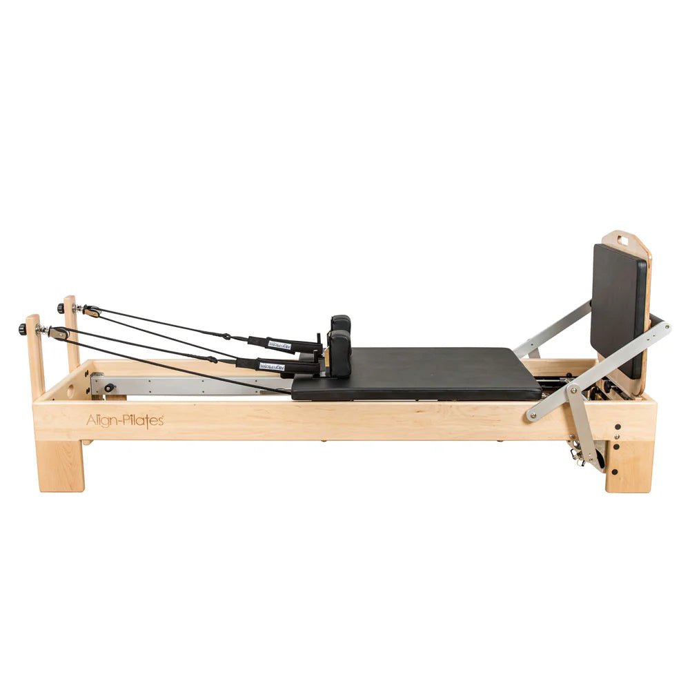 Align-Pilates Jump Board M-Serie am Ahorn-Reformer montiert – vollständige Seitenansicht des Reformers mit Ahornholz-Sprungplattform