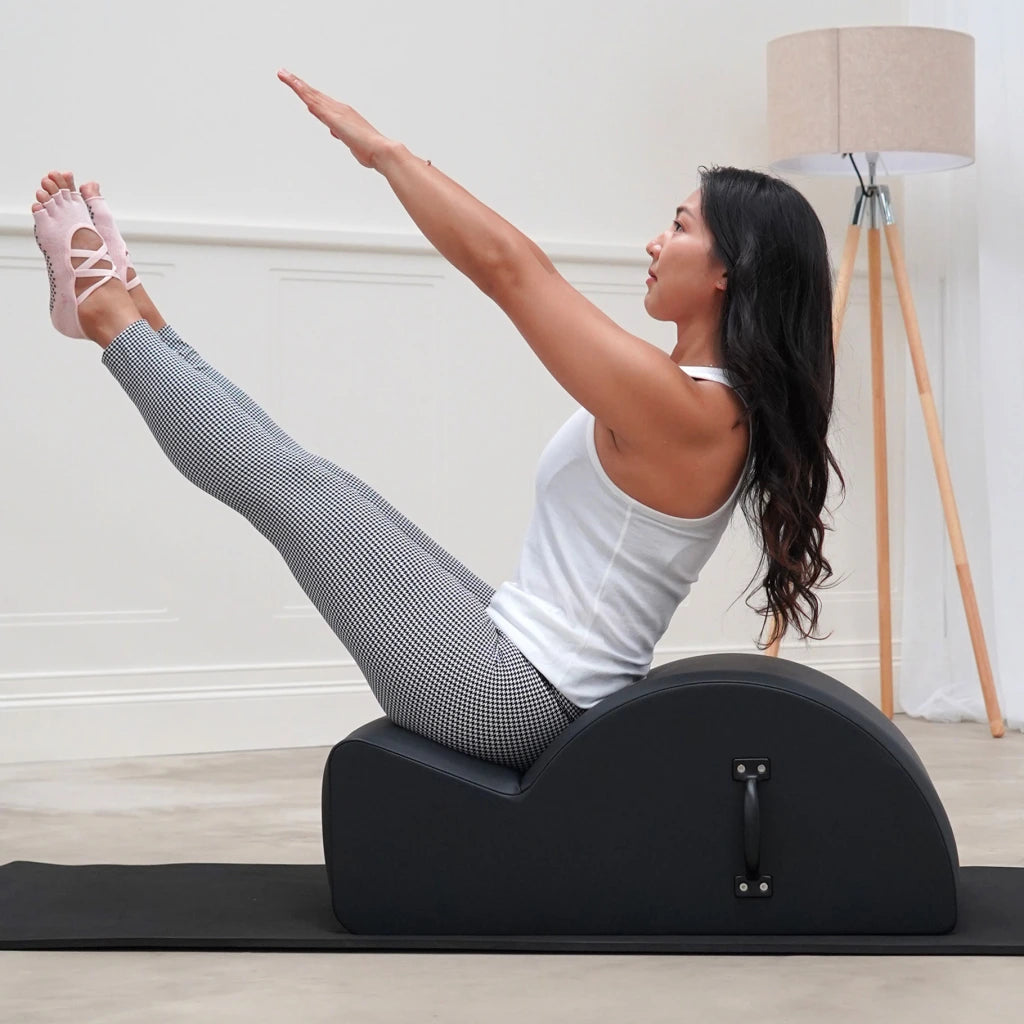 Frau trainiert die Wirbelsäule auf dem Align Pilates Spine Corrector Step Barrel