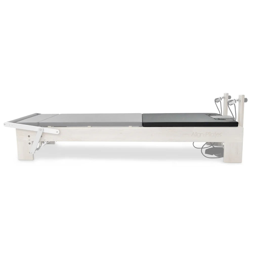 Align-Pilates Matratzen-Konverter M-Serie auf dem Ahorn-Reformer – schwarze Liegefläche mit Ahornholzrahmen, Seitenansicht