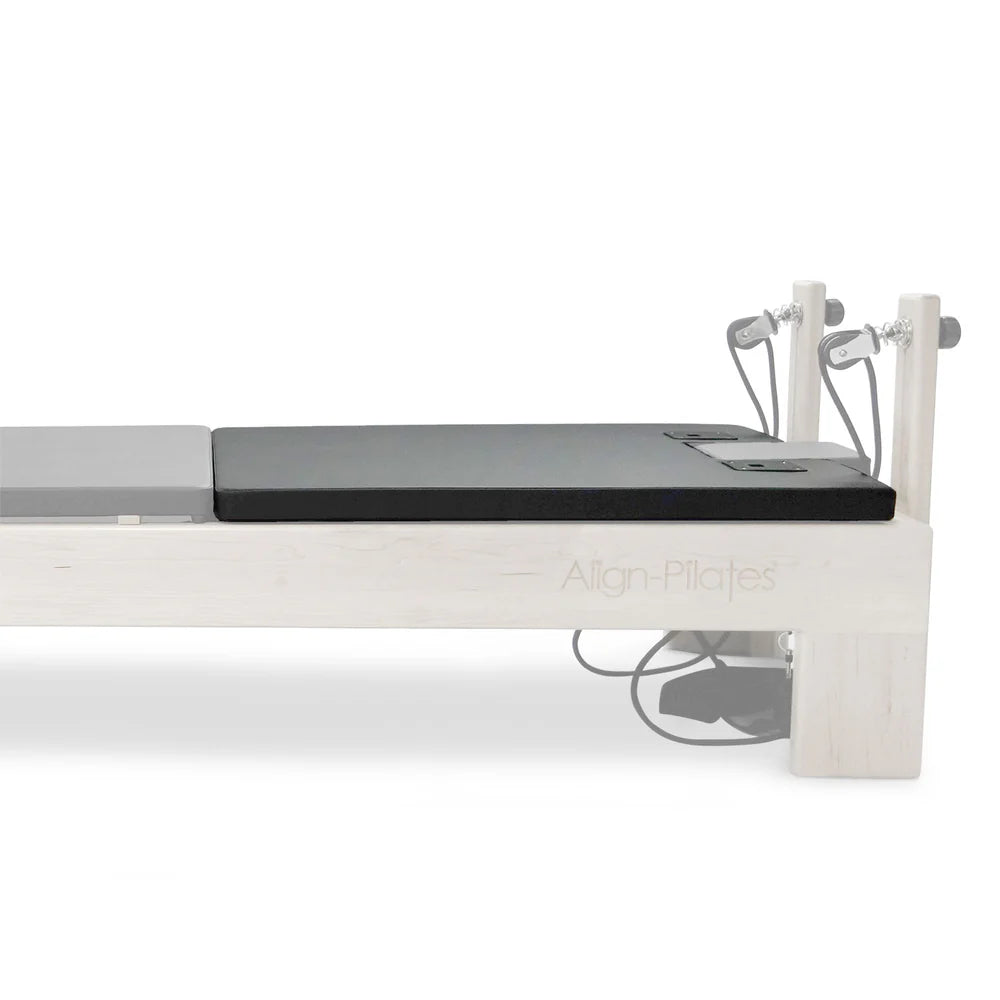 Align-Pilates Matratzen-Konverter M-Serie – Detailansicht der schwarzen Liegefläche am Reformer-Ende des Ahorn-Reformers